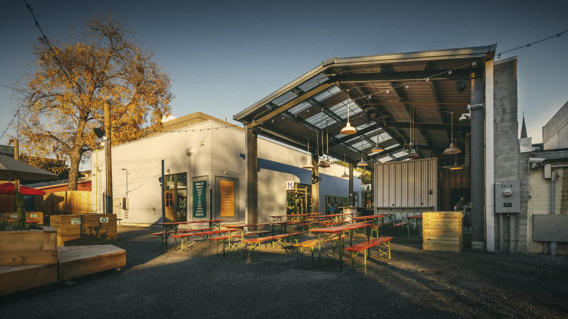 An open courtyard at dusk under a steel canopy