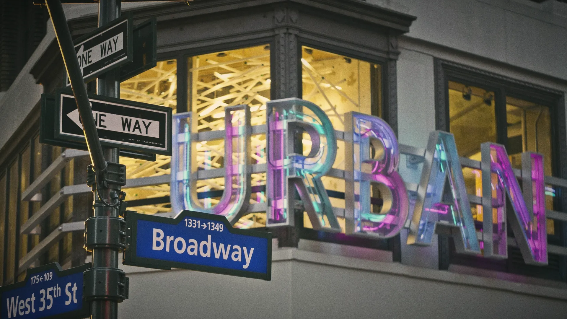 The Urban Outfitters sign lit at the corner of Broadway and West 35th Street